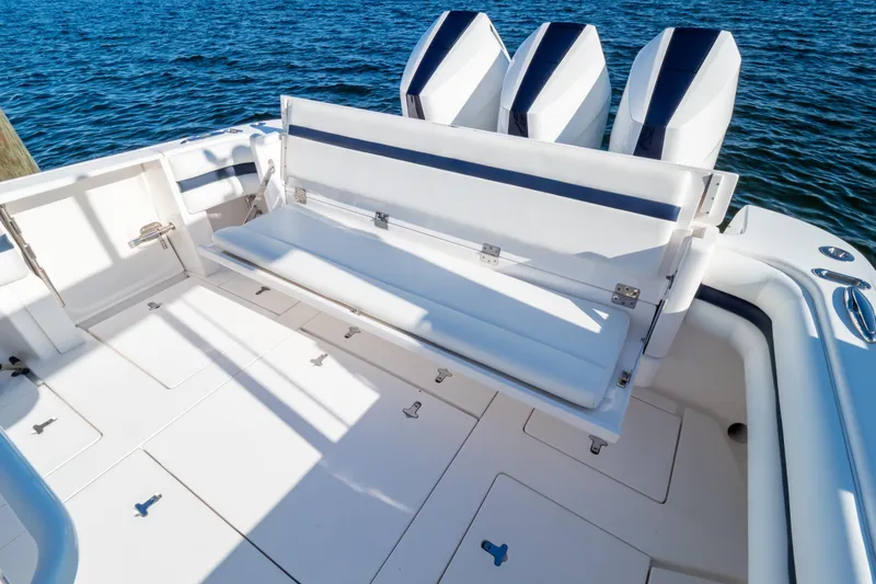 Slide: The Image of 2014 Intrepid 375 Walkaround boat with foldable seating and triple outboard engines on blue water. - 28