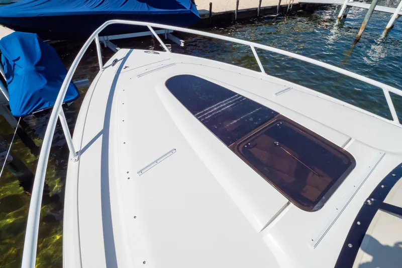 Slide: The Image of 2014 Intrepid 375 Walkaround boat deck with hatch, docked by the water. - 32