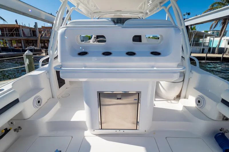 Slide: The Image of 2014 Intrepid 375 Walkaround boat interior with seating and storage, dockside view. - 41