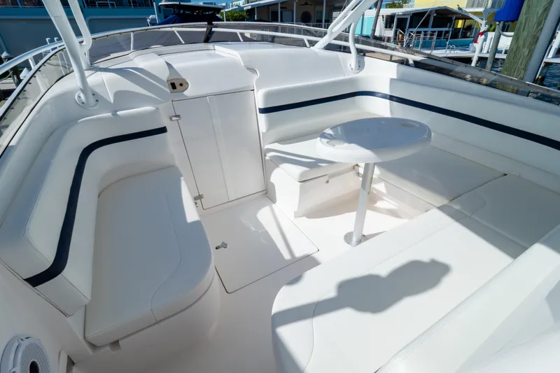 Slide: The Image of 2014 Intrepid 375 Walkaround boat interior with white seating and a small table. - 42