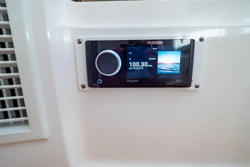 Slide: The Image of Fusion stereo system on 2014 Intrepid 375 Walkaround boat, displaying 100.30 MHz frequency. - 51