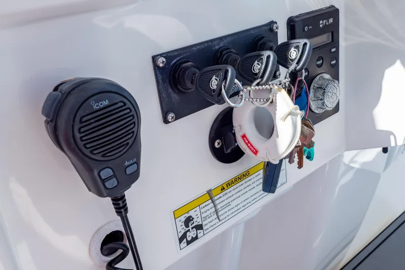Slide: The Image of Control panel of a 2014 Intrepid 375 Walkaround boat with keys and microphone. - 59