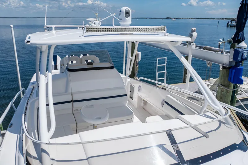 Slide: The Image of 2014 Intrepid 375 Walkaround boat docked, featuring spacious seating and sleek design. - 64