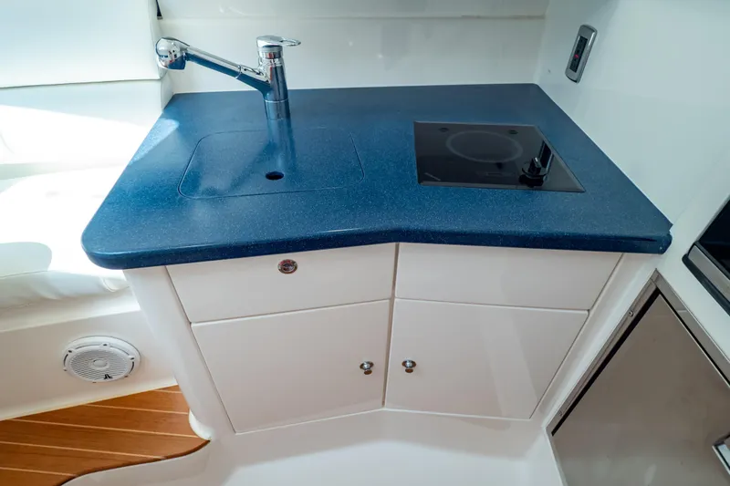 Slide: The Image of Compact kitchen area in a 2014 Intrepid 375 Walkaround boat with sink and stove. - 65
