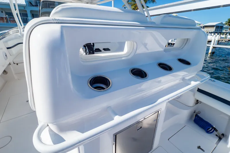 Slide: The Image of 2014 Intrepid 375 Walkaround boat interior with rod holders and storage compartment. - 67