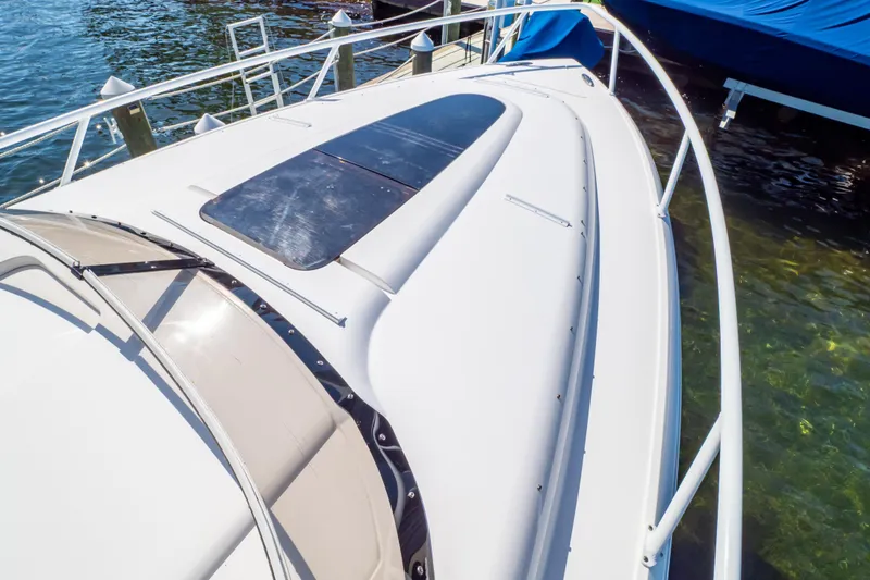 Slide: The Image of 2014 Intrepid 375 Walkaround boat docked, showcasing sleek design and spacious deck. - 7