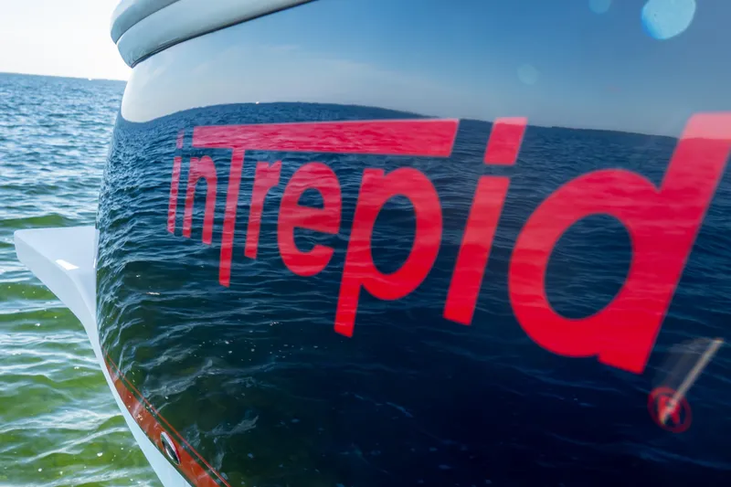 Slide: The Image of 2014 Intrepid 375 Walkaround boat on water, featuring bold red logo. - 71