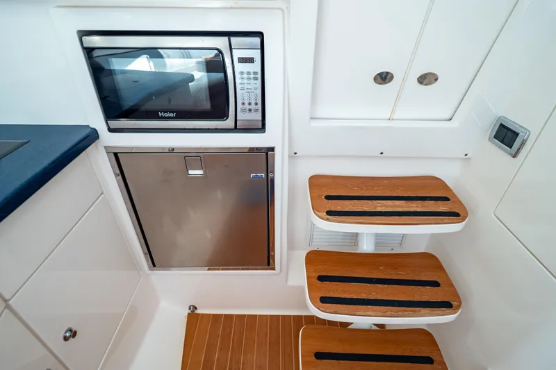 Slide: The Image of 2014 Intrepid 375 Walkaround interior with microwave, fridge, and wooden steps. - 72