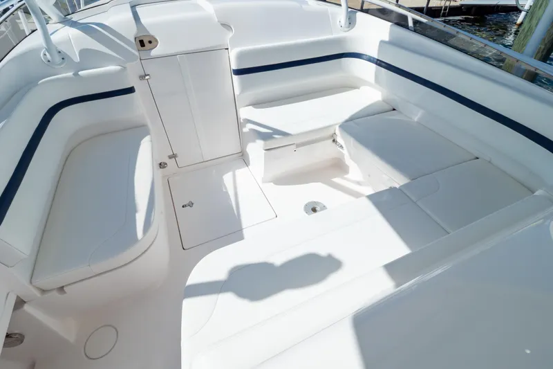 Slide: The Image of 2014 Intrepid 375 Walkaround boat interior with white seating and storage compartments. - 74