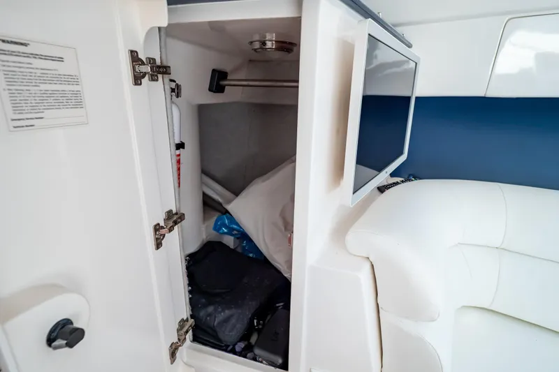 Slide: The Image of 2014 Intrepid 375 Walkaround cabin storage with TV and white seating. - 82