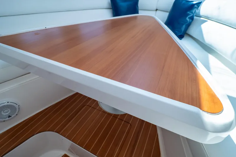 Slide: The Image of Interior view of 2014 Intrepid 375 Walkaround with wooden table and cushioned seating. - 87