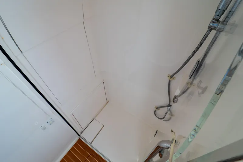 Slide: The Image of Shower area inside 2014 Intrepid 375 Walkaround boat, featuring sleek fixtures and wooden flooring. - 98