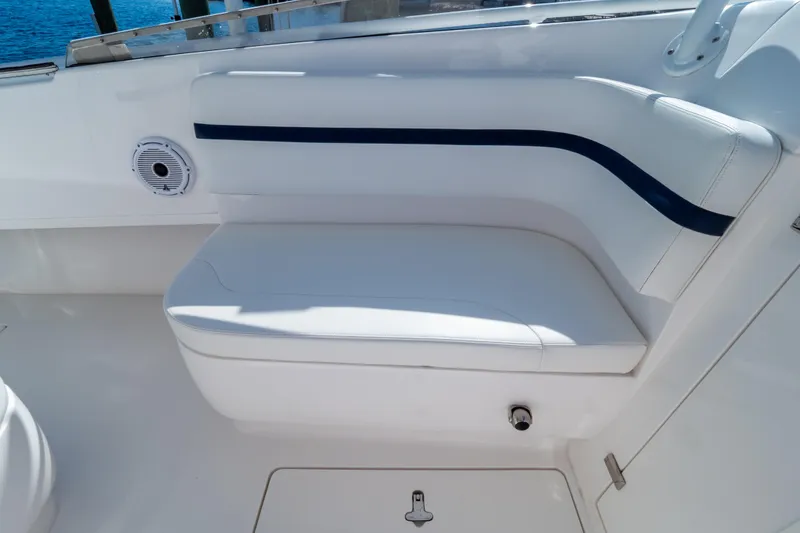 Slide: The Image of White seating area on a 2014 Intrepid 375 Walkaround boat, featuring sleek design and speaker. - 99