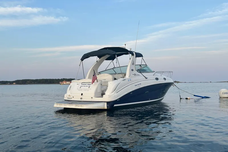 Slide: The Image of 2005 Sea Ray Sundancer 280 yacht anchored on calm water under a clear sky. - 10