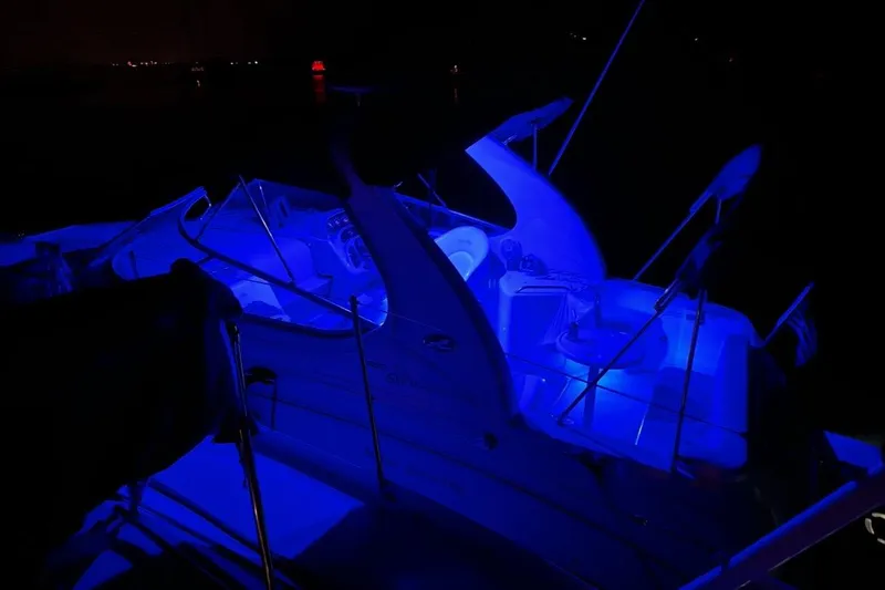 Slide: The Image of 2005 Sea Ray Sundancer 280 boat illuminated with blue lights at night. - 11