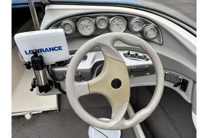 Slide: The Image of 2006 Bayliner 205 boat dashboard with steering wheel and Lowrance navigation system. - 10