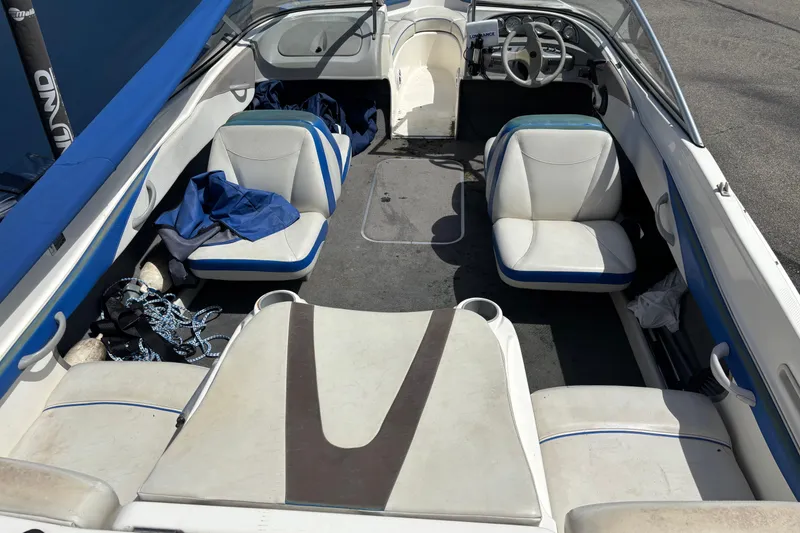 Slide: The Image of Interior of a 2006 Bayliner 205 boat with white and blue seating. - 7