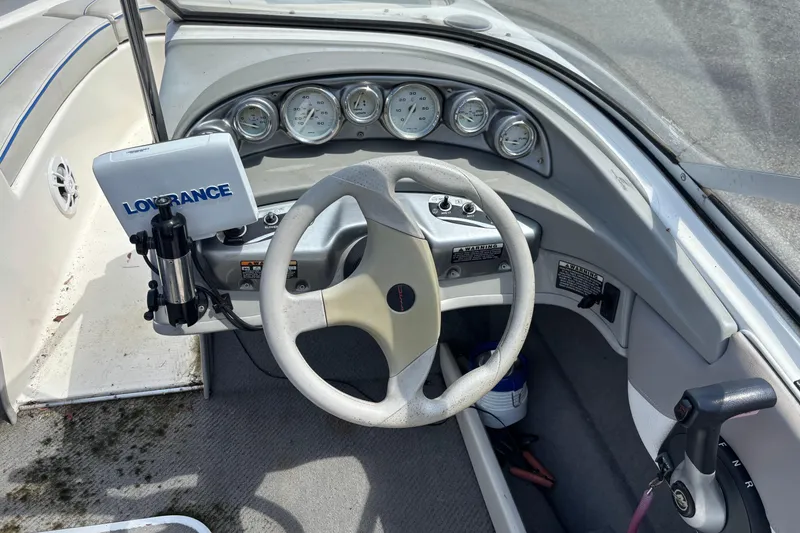 Slide: The Image of 2006 Bayliner 205 boat dashboard with steering wheel and Lowrance navigation system. - 8