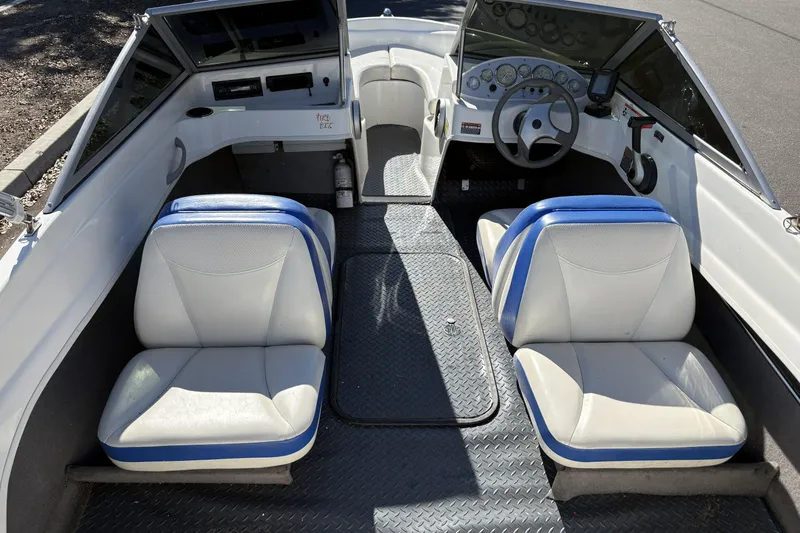 Slide: The Image of 2007 Bayliner 175 Bowrider interior with white and blue seating, steering wheel, and dashboard. - 10