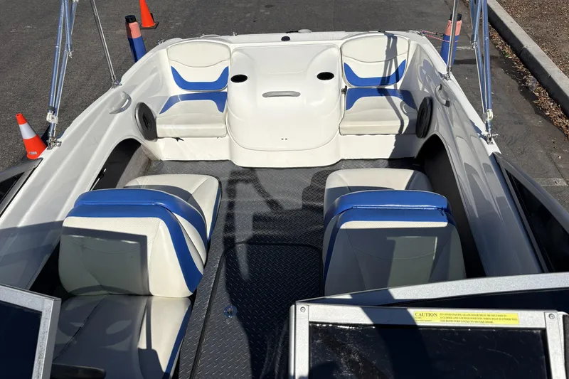 Slide: The Image of 2007 Bayliner 175 Bowrider interior with blue and white seating, parked on pavement. - 16