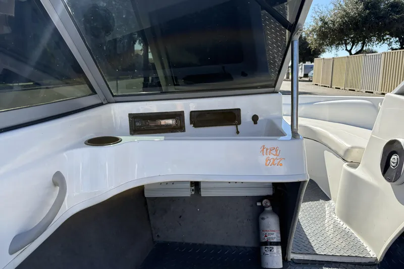 Slide: The Image of 2007 Bayliner 175 Bowrider interior with dashboard, cup holder, and fire extinguisher. - 19