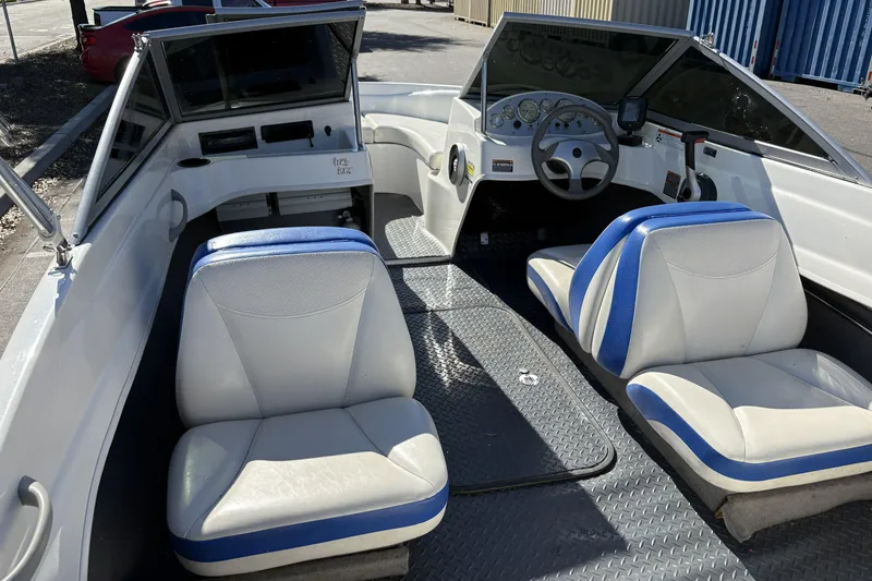 Slide: The Image of 2007 Bayliner 175 Bowrider interior with blue and white seating, steering wheel, and dashboard. - 24