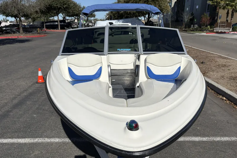 Slide: The Image of 2007 Bayliner 175 Bowrider boat parked on a street, featuring blue and white seating. - 4