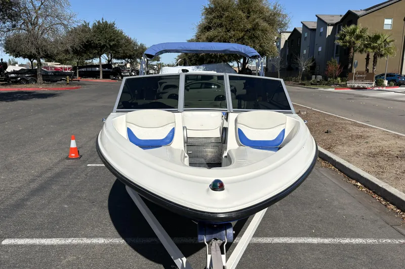 Slide: The Image of 2007 Bayliner 175 Bowrider boat parked on a street with trees and buildings. - 6