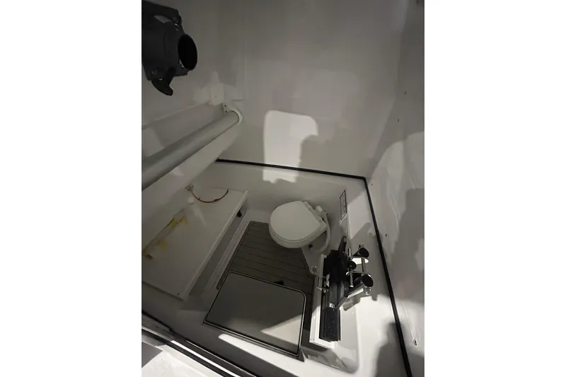 Slide: The Image of Interior of 2026 Sportsman Open 282 Center Console boat, featuring a compact marine toilet. - 6