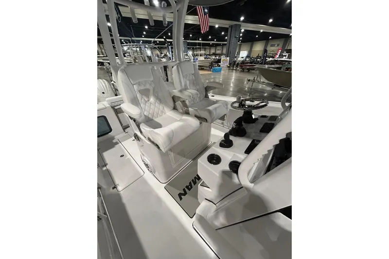 Slide: The Image of 2026 Sportsman Open 282 Center Console boat interior with white seating and steering wheel. - 7