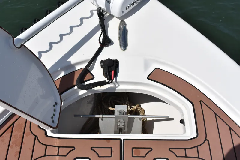Slide: The Image of 2018 Sea Pro 248 Bay boat anchor compartment with rope and Minn Kota trolling motor. - 11
