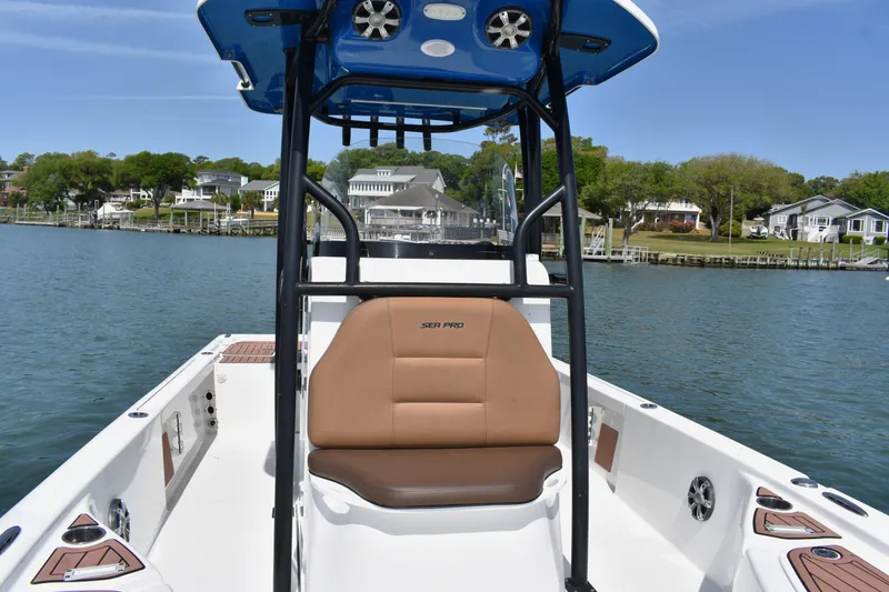Slide: The Image of 2018 Sea Pro 248 Bay boat interior with seating, on a scenic waterfront. - 12
