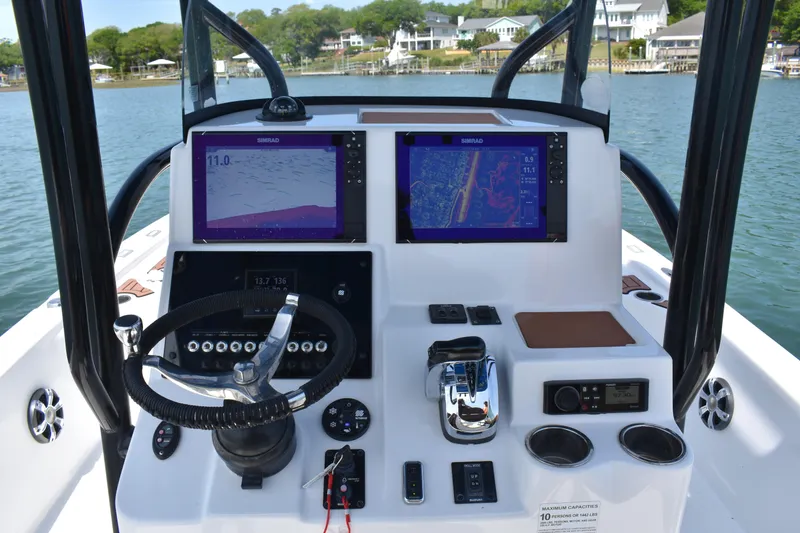 Slide: The Image of 2018 Sea Pro 248 Bay boat dashboard with dual Simrad displays and steering wheel. - 13