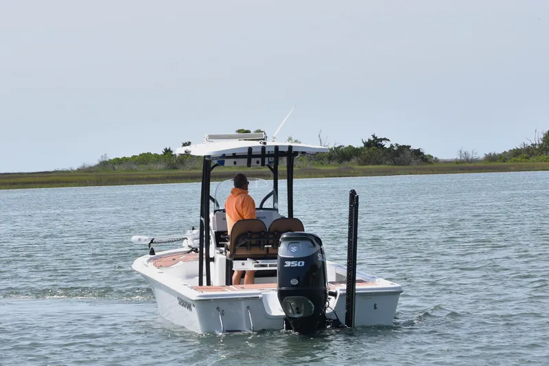 Slide: The Image of 2018 Sea Pro 248 Bay boat cruising on calm water with lush shoreline. - 2