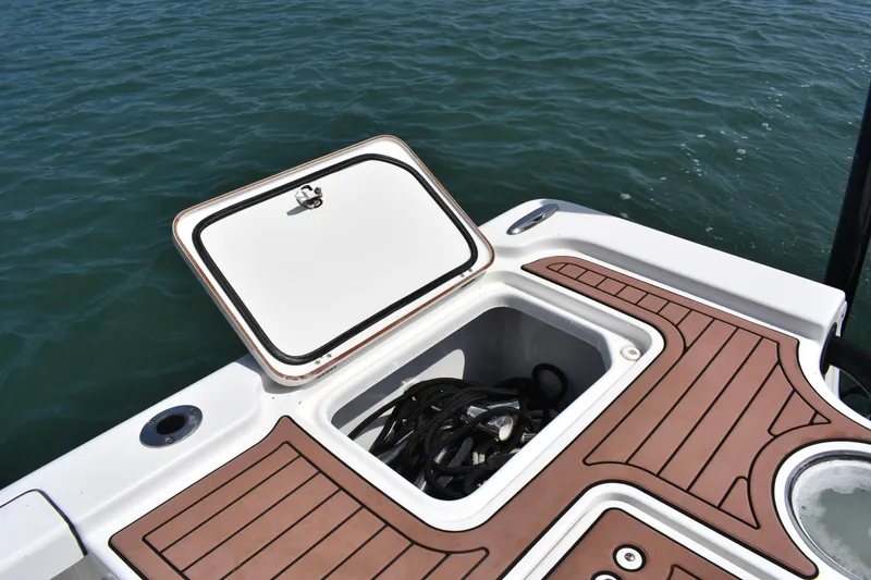 Slide: The Image of Open storage compartment on 2018 Sea Pro 248 Bay boat, with ropes inside, on water. - 20