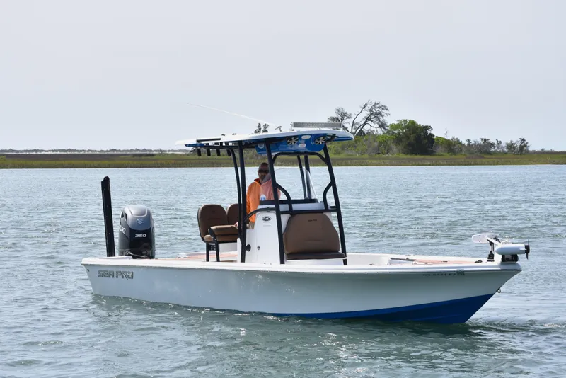 Slide: The Image of 2018 Sea Pro 248 Bay boat cruising on calm water with scenic background. - 4