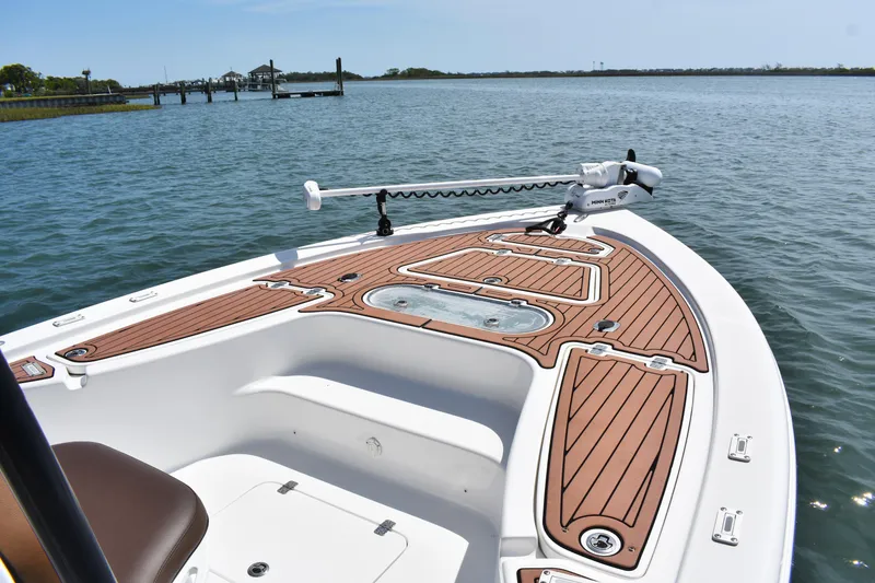 Slide: The Image of 2018 Sea Pro 248 Bay boat with wooden deck, docked on calm water. - 6