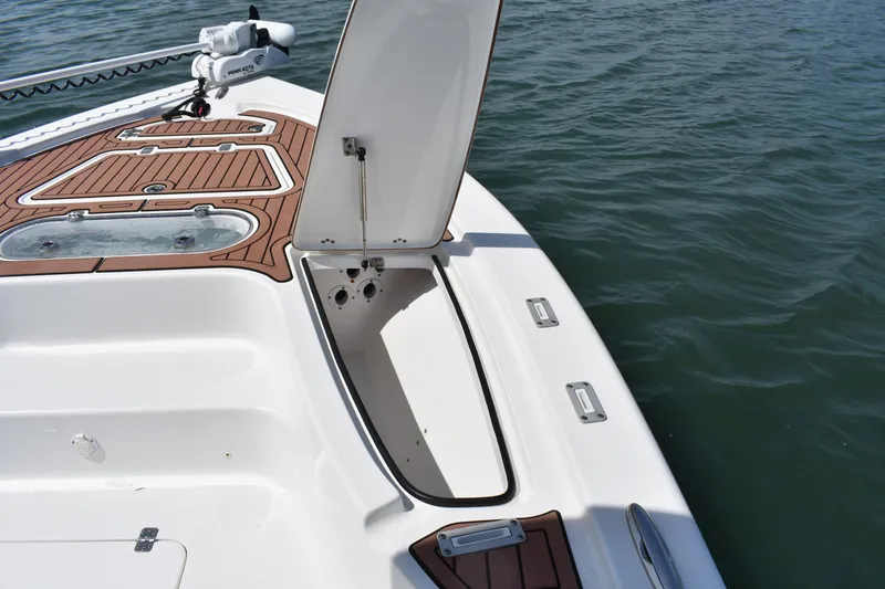Slide: The Image of 2018 Sea Pro 248 Bay boat deck with open storage compartment on water. - 8