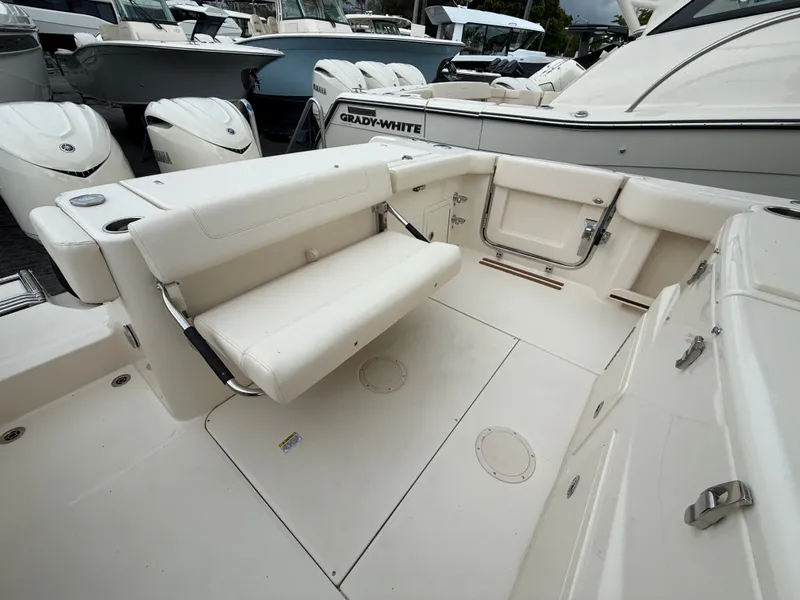 Slide: The Image of The image shows the cockpit of a Grady-White Canyon 306 boat with white seating and storage. - 10