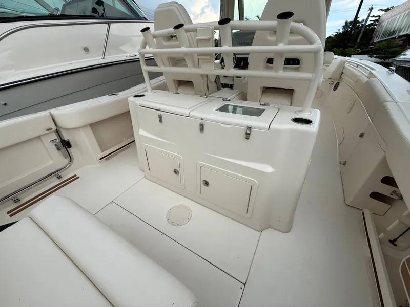 Slide: The Image of The image shows the cockpit of a Grady-White Canyon 306 boat with white seating and storage. - 9