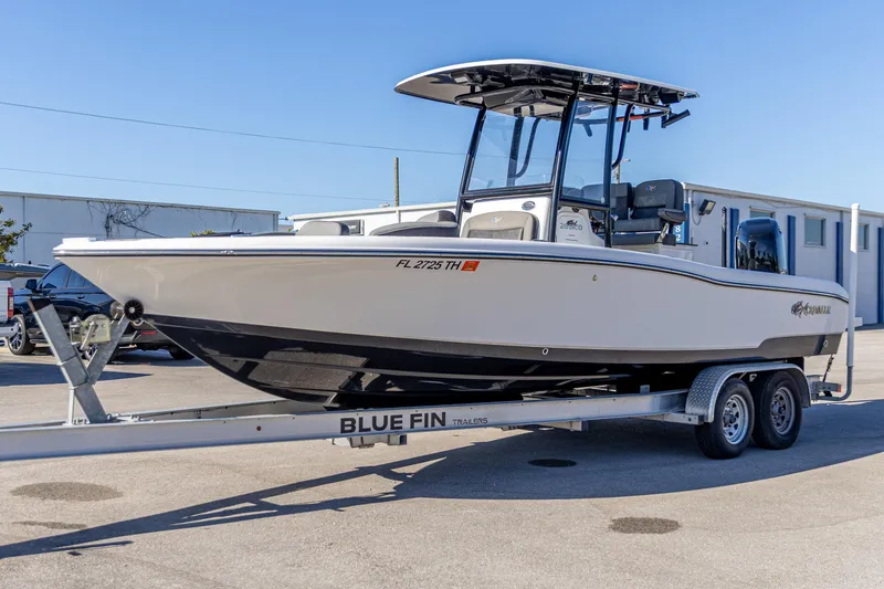 Slide: The Image of 2022 Crevalle 26 HCO boat on trailer, parked outdoors under clear blue sky. - 13