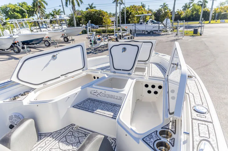Slide: The Image of 2022 Crevalle 26 HCO boat with open storage compartments in a sunny marina. - 2