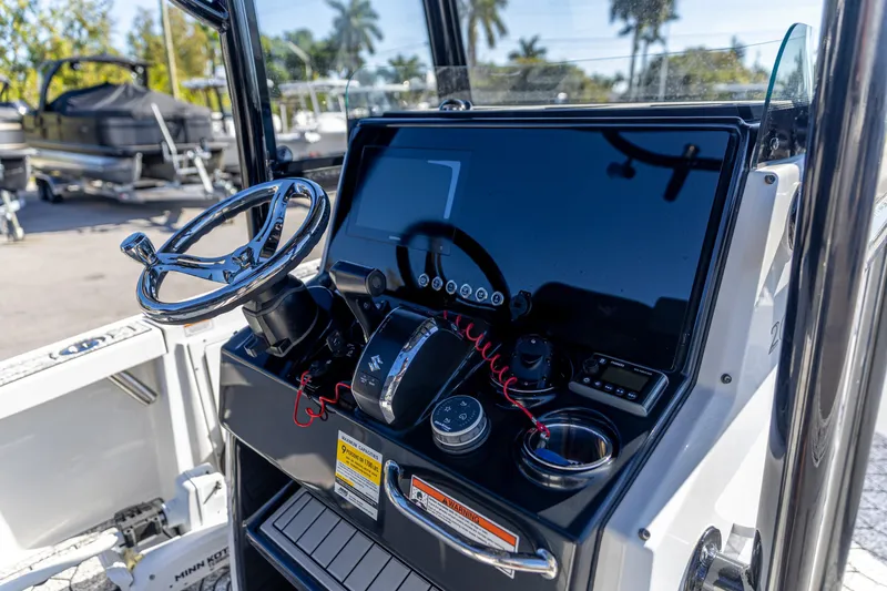 Slide: The Image of 2022 Crevalle 26 HCO boat dashboard with steering wheel and controls. - 3