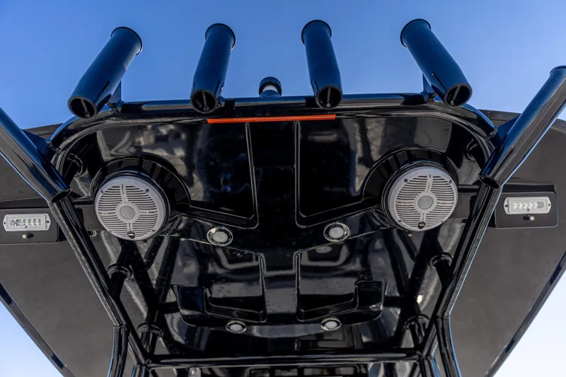 Slide: The Image of Crevalle 26 HCO 2022 boat roof with rod holders and speakers against blue sky. - 9