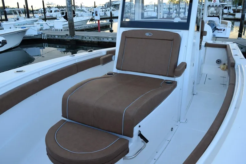 Slide: The Image of 2025 Sea Hunt Gamefish 28 Coffin Box boat interior with brown seating at marina. - 12