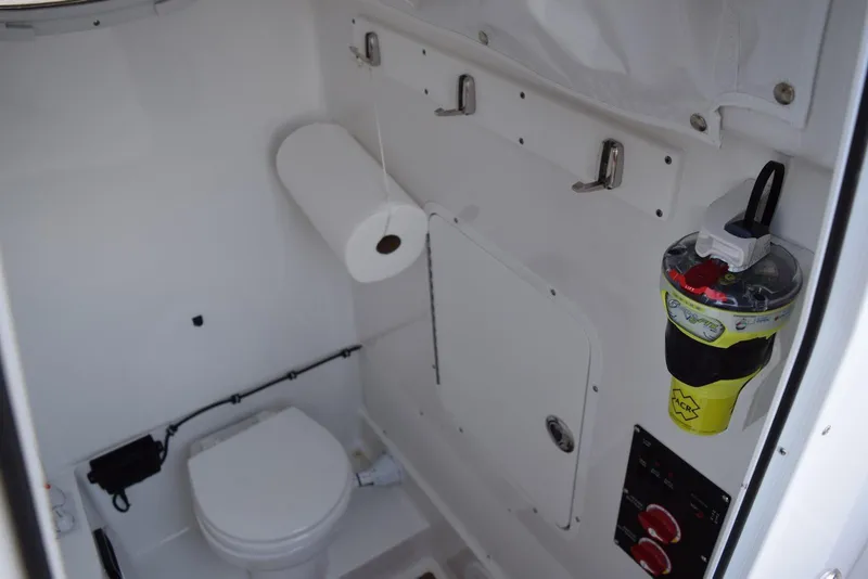 Slide: The Image of Interior of 2025 Sea Hunt Gamefish 28 Coffin Box boat, featuring a compact marine toilet. - 16