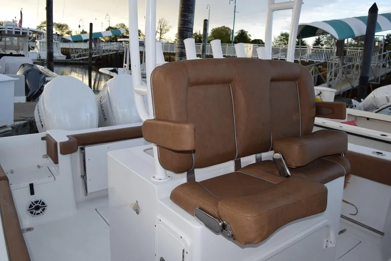 Slide: The Image of 2025 Sea Hunt Gamefish 28 Coffin Box boat interior with brown seating at marina. - 7