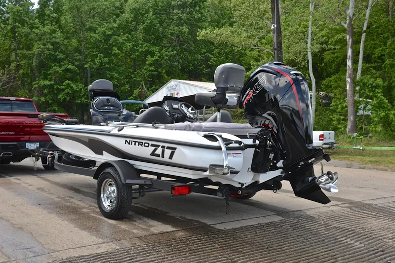 Slide: The Image of 2025 Nitro Z17 boat on trailer, parked near lush green trees. - 11
