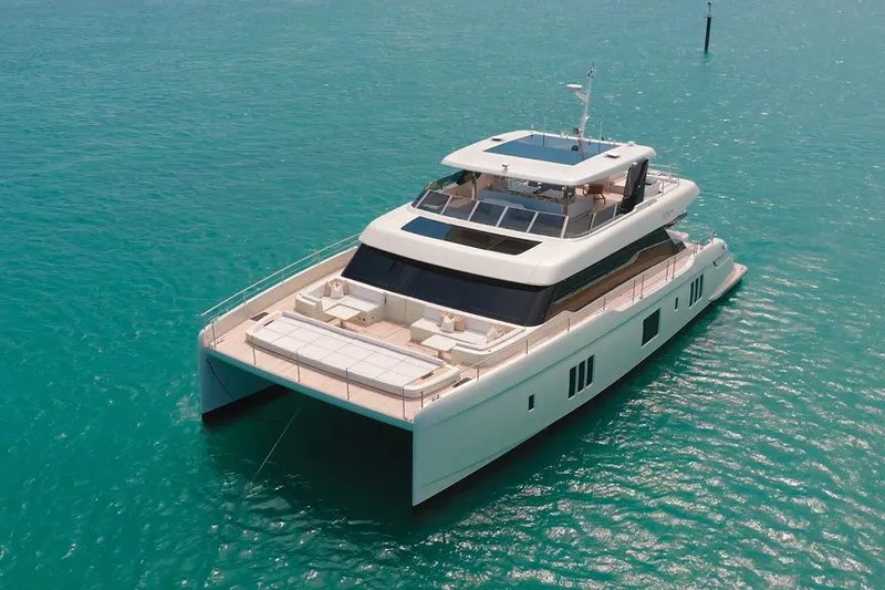 Slide: The Image of Luxurious 2024 Sunreef 80 Power yacht on turquoise water, showcasing sleek design and spacious deck. - 11