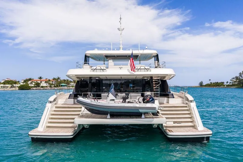 Slide: The Image of 2024 Sunreef 80 Power yacht with tender, anchored in clear blue waters. - 12